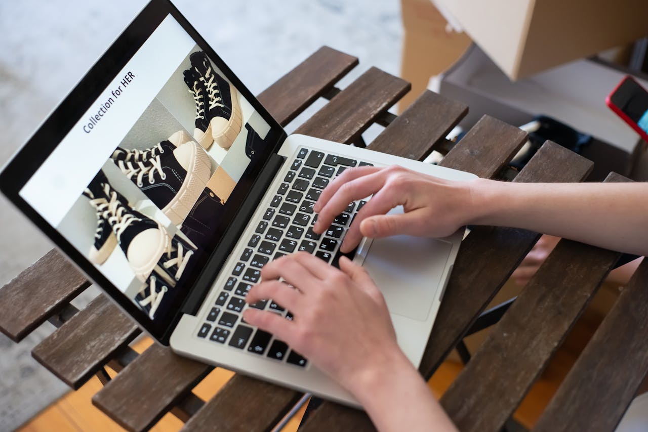 services-img Hands of a person browsing a Collection for HER on an online shoe store using a laptop.